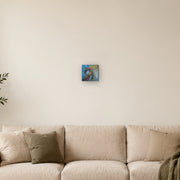 Do not mistake silence for surrender! canvas print by Artis Berkmanis, a wild horse in thick red, green and dark strokes against a blue and yellow sky. Shown at 15 x 15 cm above a sofa in a Scandinavian living room.