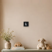 I am not as small as I look canvas print by Artis Berkmanis, a small white kitten stepping out of a black background. Shown at 15 x 15 cm in a Scandinavian children's room.