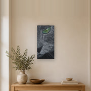 I saw you first canvas print by Artis Berkmanis, a grey cat's green eye watching from the dark. Shown at 25 x 51 cm in a Scandinavian hallway.