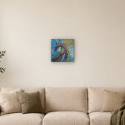 Do not mistake silence for surrender! canvas print by Artis Berkmanis, a wild horse in thick red, green and dark strokes against a blue and yellow sky. Shown at 30 x 30 cm above a sofa in a Scandinavian living room.