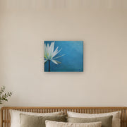 I am canvas print by Artis Berkmanis, a white water lily on a deep blue background. Shown at 51 x 41 cm above a bed in a calm Scandinavian bedroom.