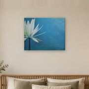 I am canvas print by Artis Berkmanis, a white water lily on a deep blue background. Shown at 76 x 61 cm above a bed in a calm Scandinavian bedroom.