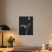 At least I tried art poster by Artis Berkmanis, a small black cat reaching one paw towards a white crescent moon in a dark night sky. Unframed matte print shown at 30 x 40 cm above a desk in a Scandinavian home office.