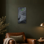 I saw you first canvas print by Artis Berkmanis, a grey cat's green eye watching from the dark. Shown at 30 x 61 cm on a dark wall in a cosy living room.