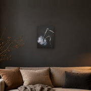 The night did not keep him canvas print by Artis Berkmanis, the white outline of a horse's head, its breath turning to mist on a black background. Shown at 30 x 41 cm on a dark wall in a cosy living room.