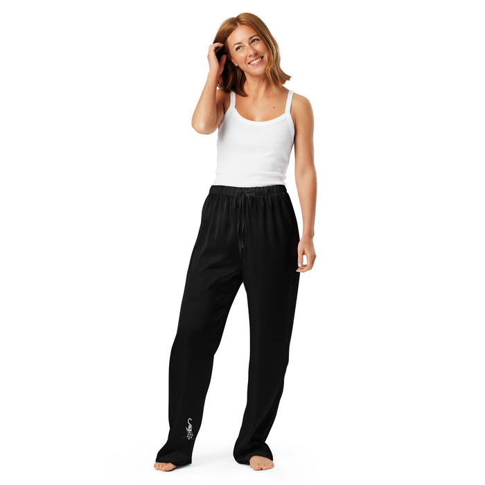I am not as small as I look pyjama pants by Art-is-Artis – black silky pyjama pants with a small white kitten on the leg, worn by a model, front view