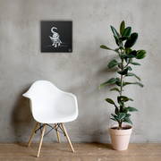 I am not as small as I look canvas print by Artis Berkmanis on a light grey wall above a white chair and a potted plant