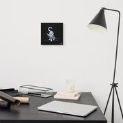 I am not as small as I look canvas print by Artis Berkmanis on a light wall above a desk with a black floor lamp