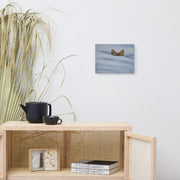 I am not lost, only hiding canvas print by Artis Berkmanis above a wooden sideboard with books and a plant